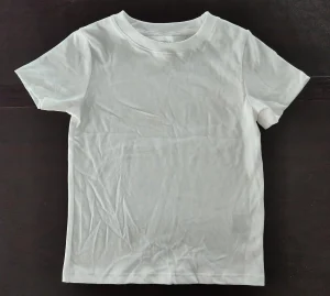 Shirt Parts Name: Easy Overview with Size Chart Guide a white t-shirt on the table